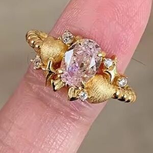 Gold Ring with bow and little hearts and a center pink gemstone